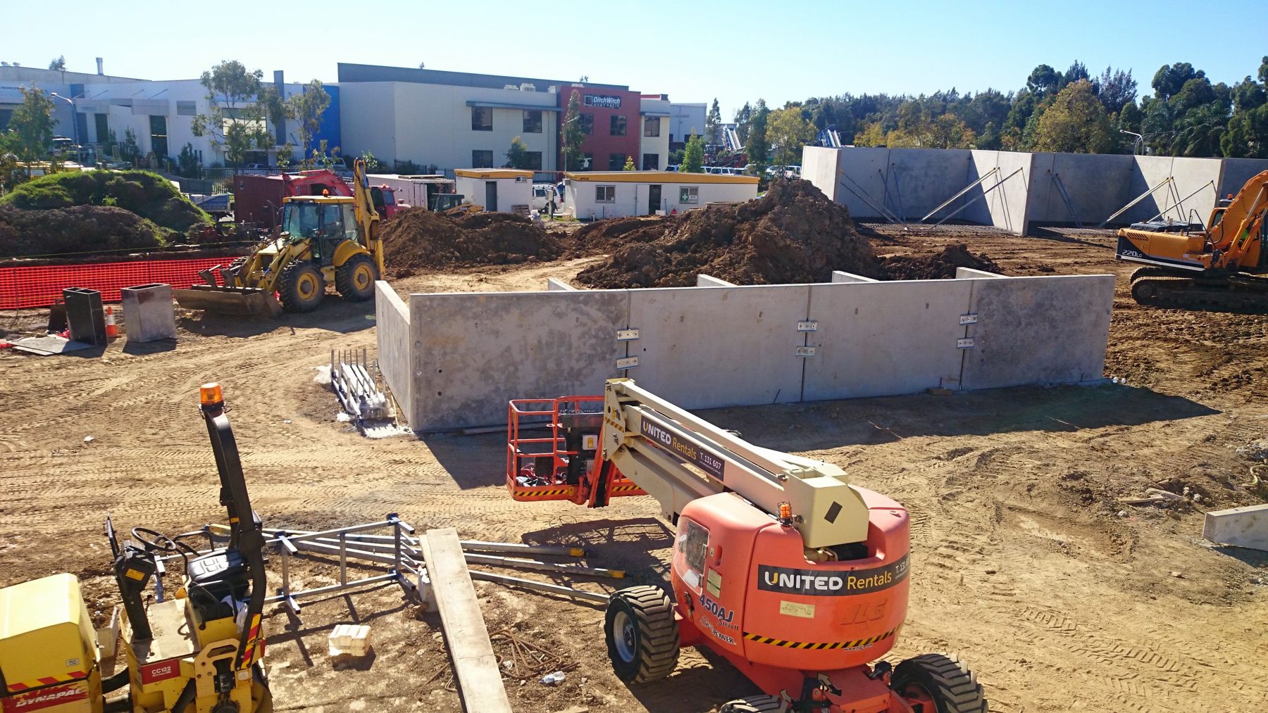 Earthmoving machinery working beside a new concrete structure