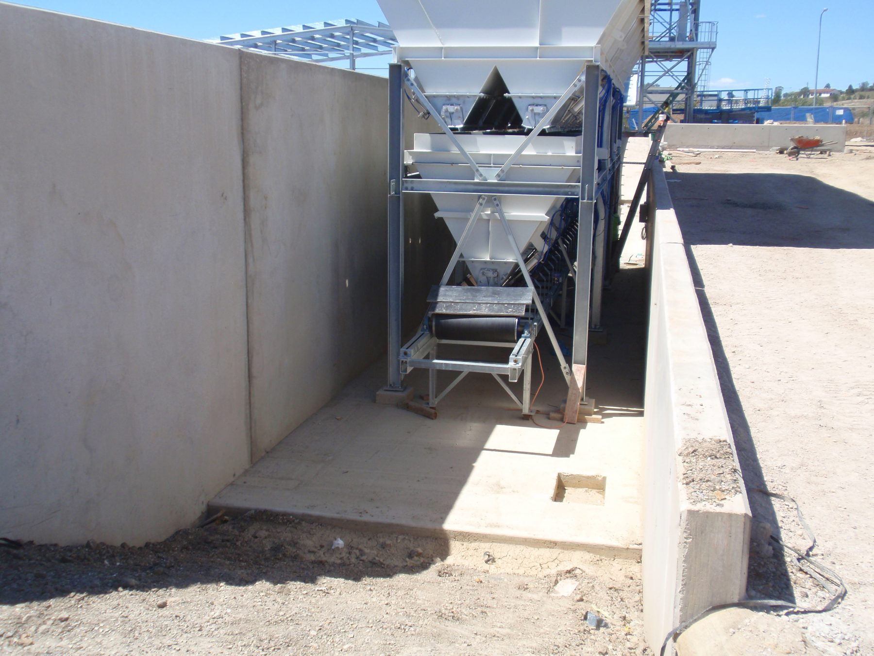 Concrete ground bin walls with a hopper at a batching plant